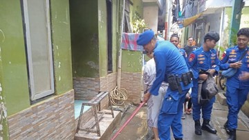 Polairud Polda Metro Bantu Bersihkan Lumpur Sisa Banjir di Kampung Melayu